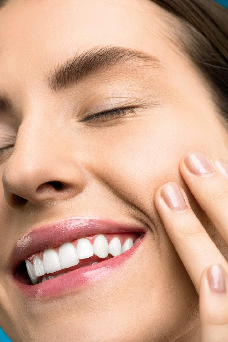 Smiling woman feeling her own face.