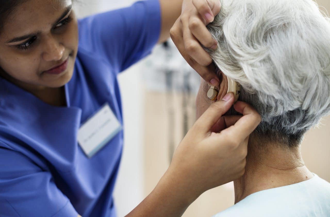 An elderly woman with hearing aid